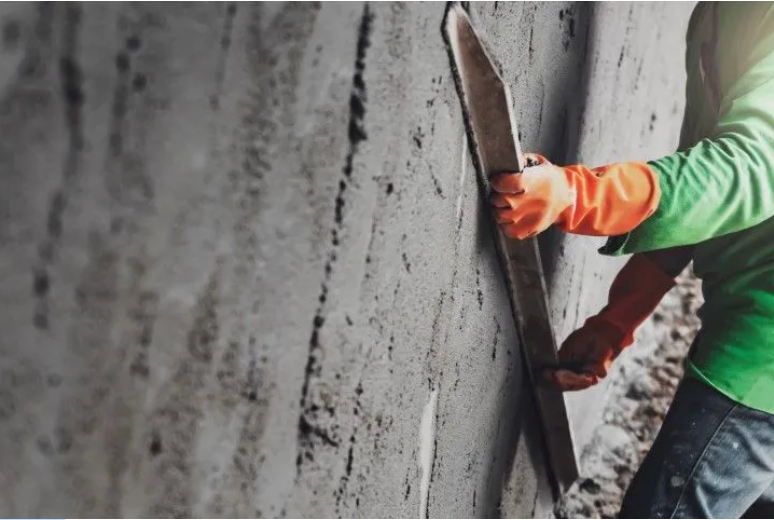 Worker troweling a concrete retaining wall in Renton WA